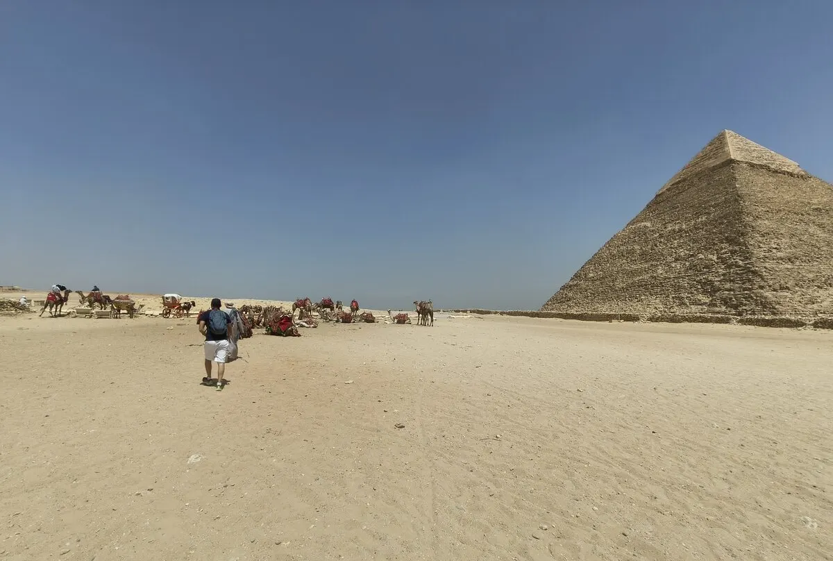 Aux pyramides de Gizeh, en marchant vers le plateau au milieu des chameaux